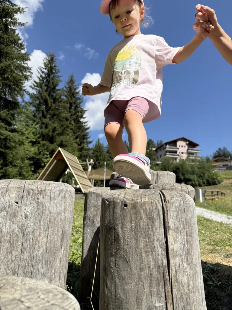 Valbella, Spielplatz, Lea am balancieren auf Holzpflöcken